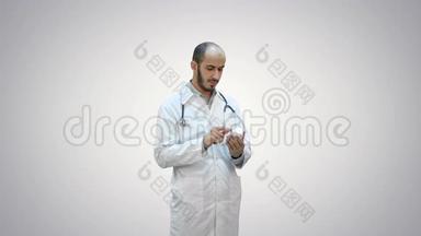男医生在白色背景上仔细阅读一瓶药丸的<strong>药品标签</strong>。